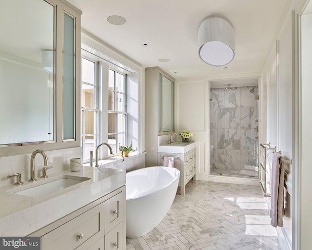 full bath featuring a stall shower, a freestanding tub, two vanities, and a sink