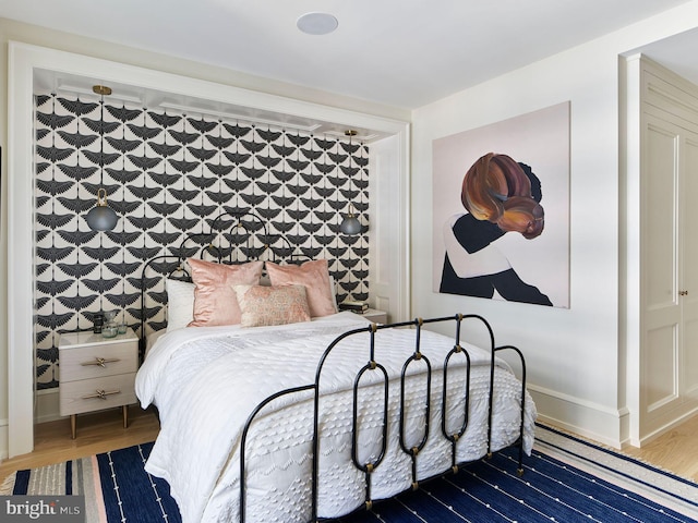 bedroom featuring baseboards and wood finished floors