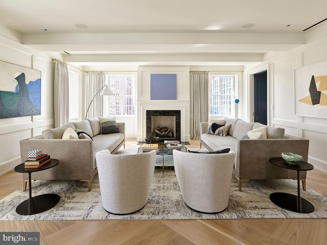 living area featuring a premium fireplace, a decorative wall, and wood finished floors