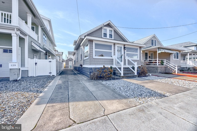 view of front of house featuring a residential view, a gate, and concrete driveway