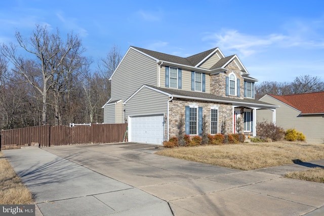 view of front of property with stone siding, fence, concrete driveway, and an attached garage