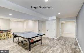 recreation room with baseboards, wood finished floors, and recessed lighting