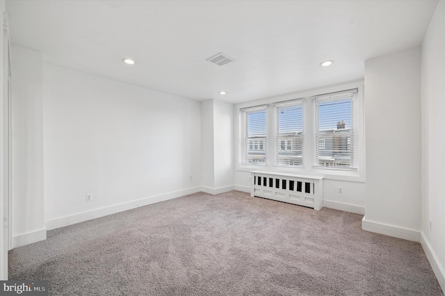 carpeted empty room with baseboards, visible vents, and recessed lighting