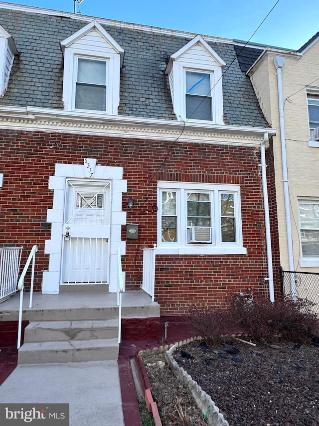 view of front of property featuring brick siding and mansard roof