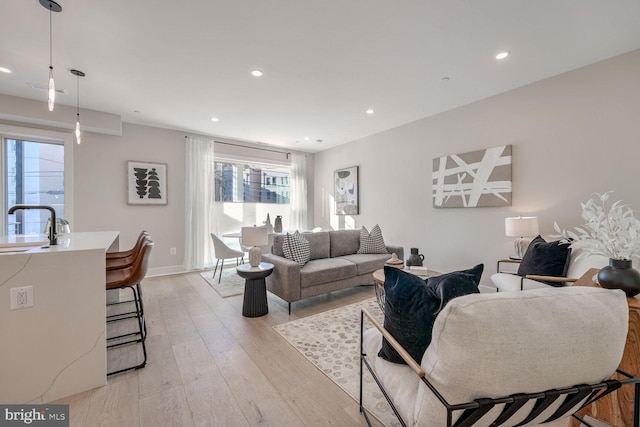 living room with light wood-type flooring, baseboards, and recessed lighting