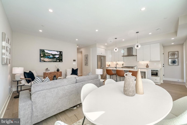 dining room featuring light wood-style floors, baseboards, and recessed lighting