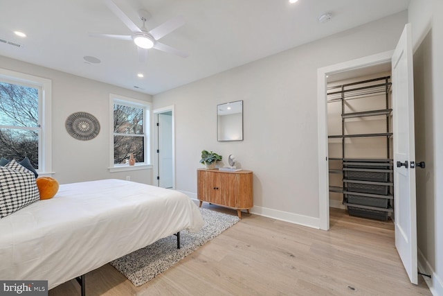 bedroom with visible vents, baseboards, light wood-style flooring, a walk in closet, and recessed lighting