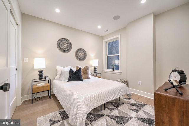 bedroom with light wood-style floors, recessed lighting, visible vents, and baseboards