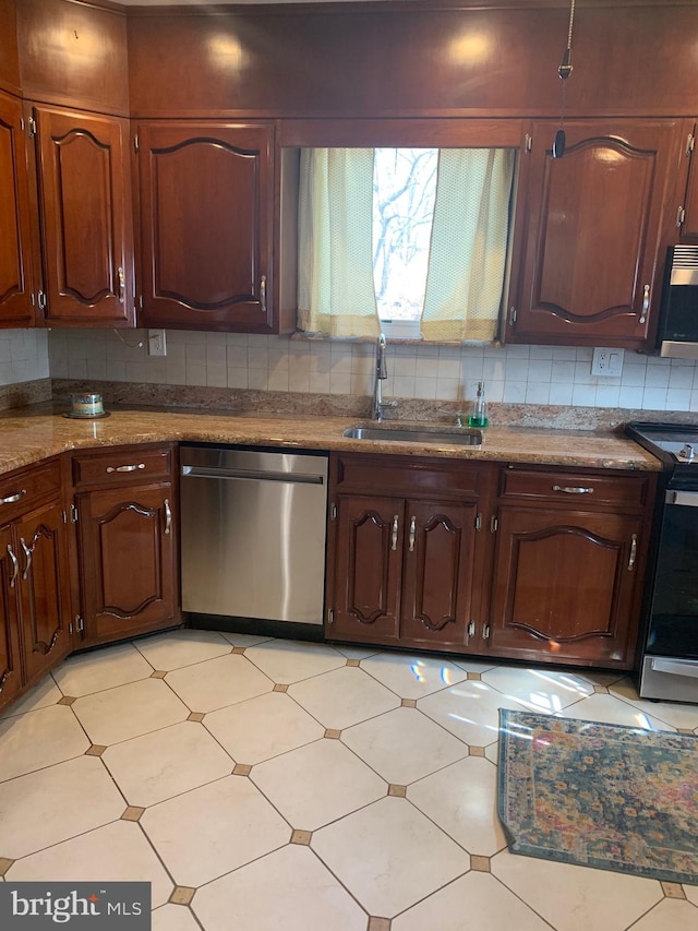 kitchen with stainless steel appliances, stone countertops, a sink, and decorative backsplash