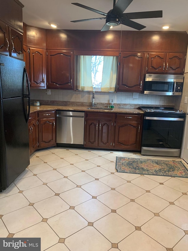 kitchen with backsplash, stainless steel appliances, a sink, and light floors