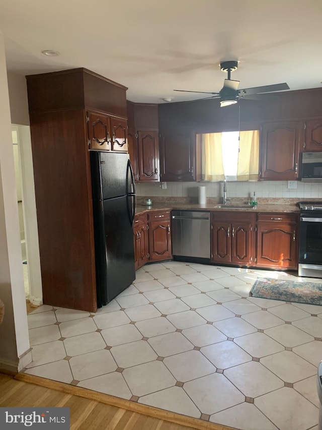 kitchen with appliances with stainless steel finishes, a sink, light floors, and ceiling fan