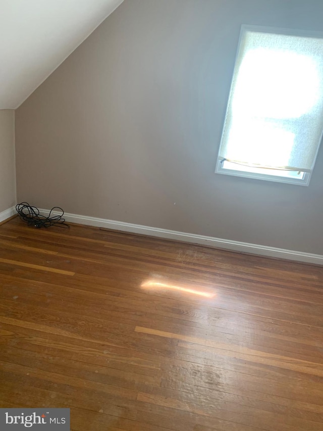 bonus room with vaulted ceiling, baseboards, and wood finished floors