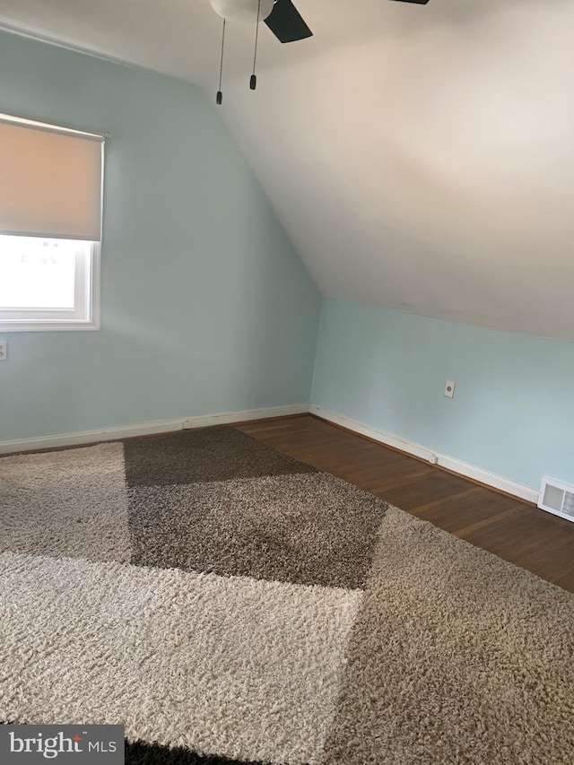 bonus room with lofted ceiling, ceiling fan, wood finished floors, visible vents, and baseboards