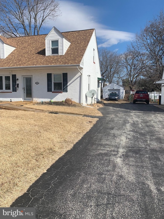 view of front of home with a shingled roof and driveway