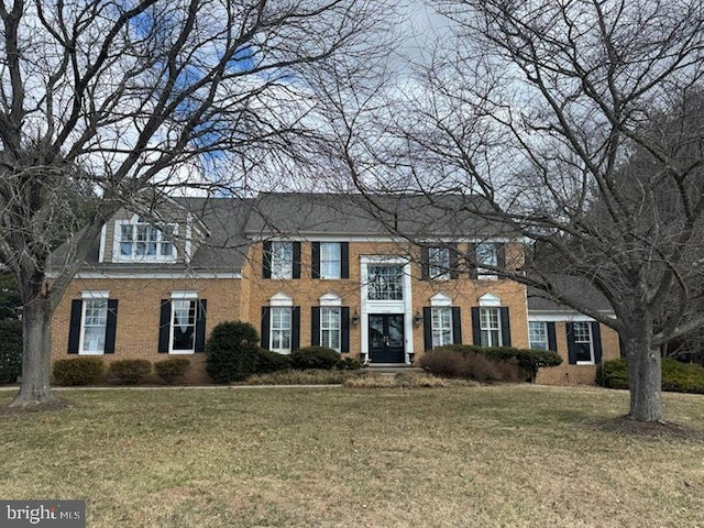 view of front of house featuring a front lawn and brick siding