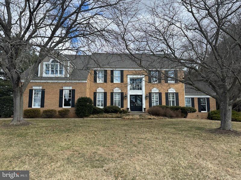 view of front of home featuring a front lawn and brick siding