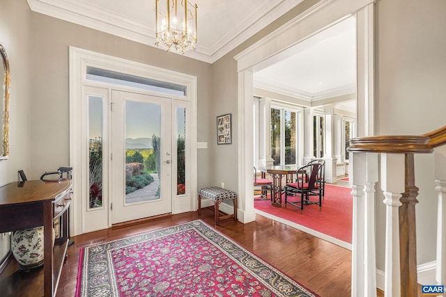 entryway featuring baseboards, stairway, ornamental molding, wood finished floors, and a chandelier