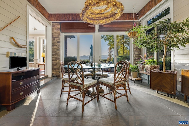 dining space featuring wood walls and a chandelier