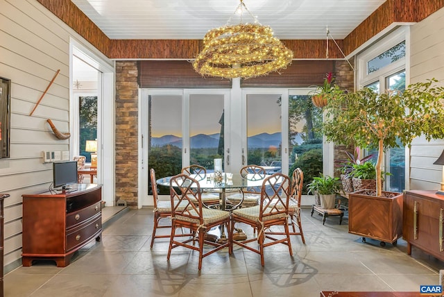 sunroom / solarium featuring an inviting chandelier