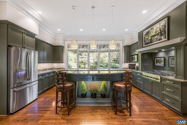 kitchen featuring light stone counters, stainless steel appliances, an island with sink, a kitchen bar, and crown molding