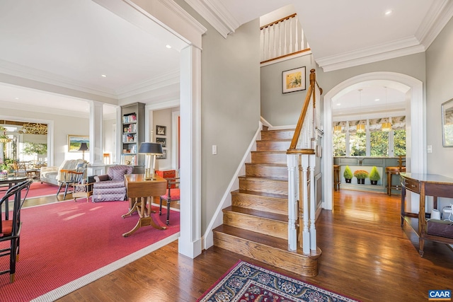 stairs featuring ornamental molding, ornate columns, and wood finished floors