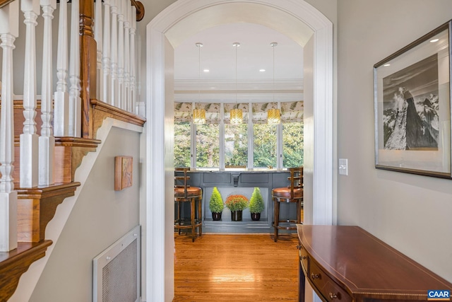 entryway featuring stairs, crown molding, heating unit, and wood finished floors