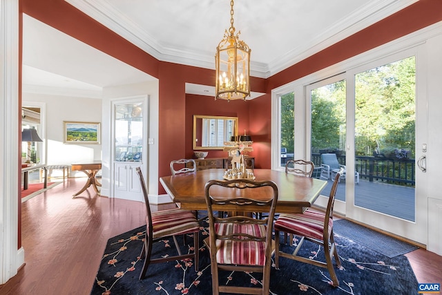 dining area featuring a notable chandelier, baseboards, wood finished floors, and crown molding