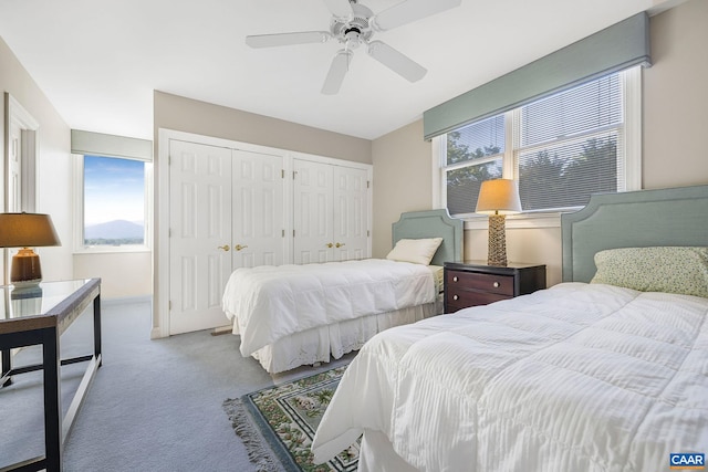 bedroom featuring multiple closets, carpet flooring, and ceiling fan