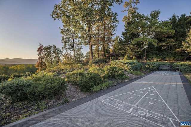 view of community with shuffleboard and uncovered parking