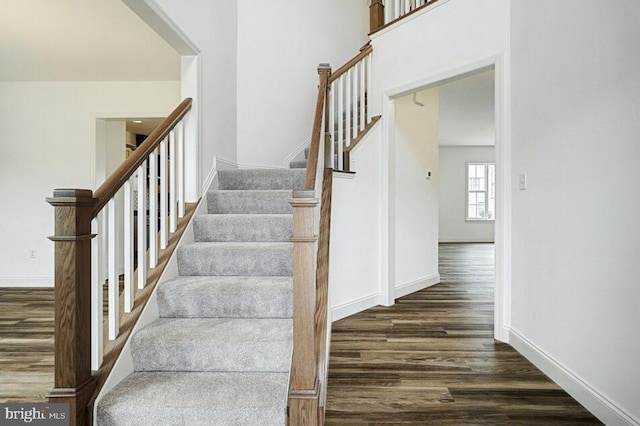 stairs with wood finished floors and baseboards