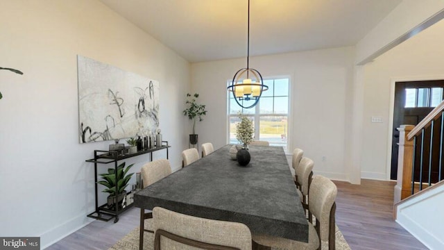 dining space with stairs, wood finished floors, and baseboards