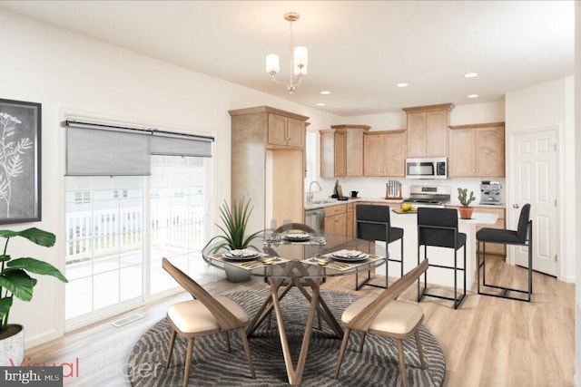 dining space featuring light wood-style floors, recessed lighting, visible vents, and an inviting chandelier