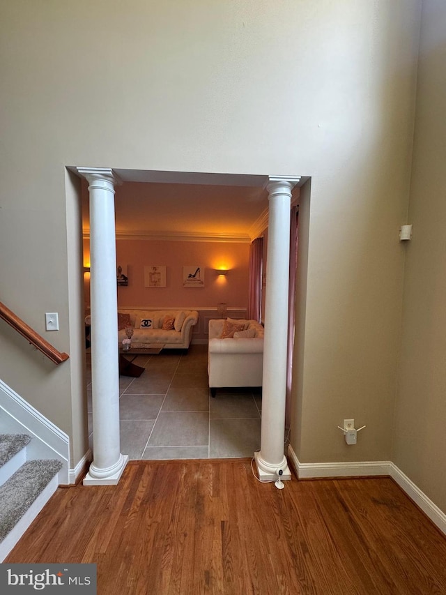 unfurnished bedroom with ornate columns, baseboards, and wood finished floors