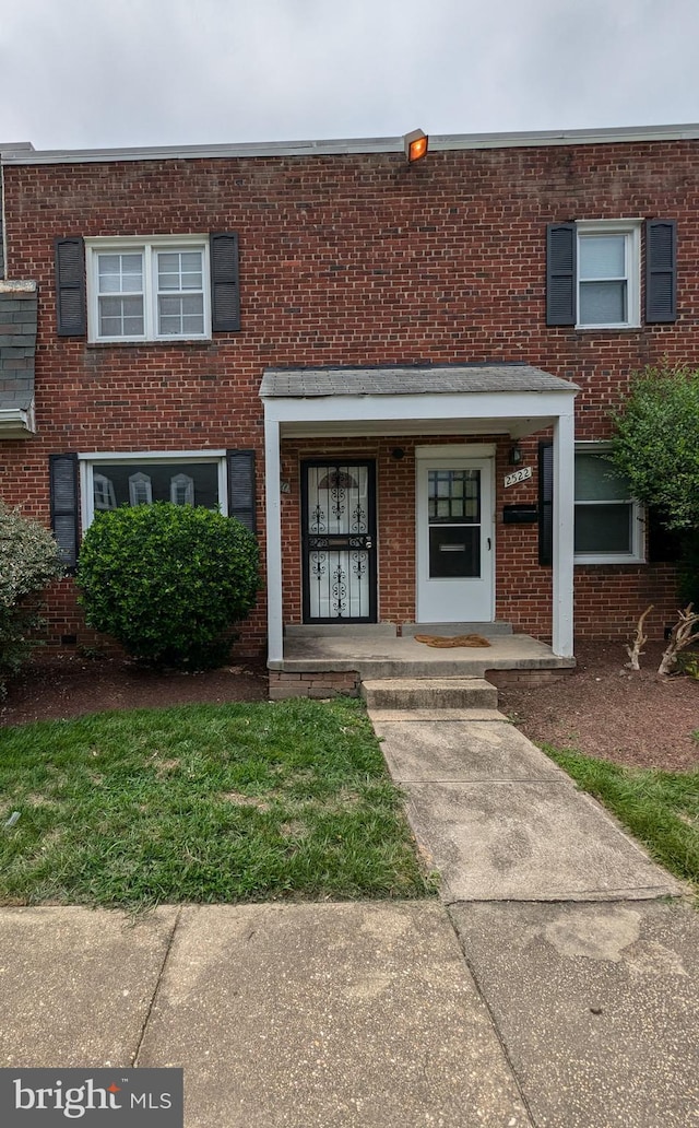 view of front facade featuring covered porch and brick siding