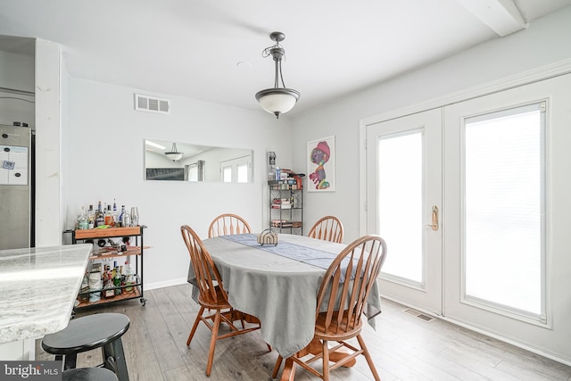 dining room with french doors, light wood-style flooring, visible vents, and baseboards