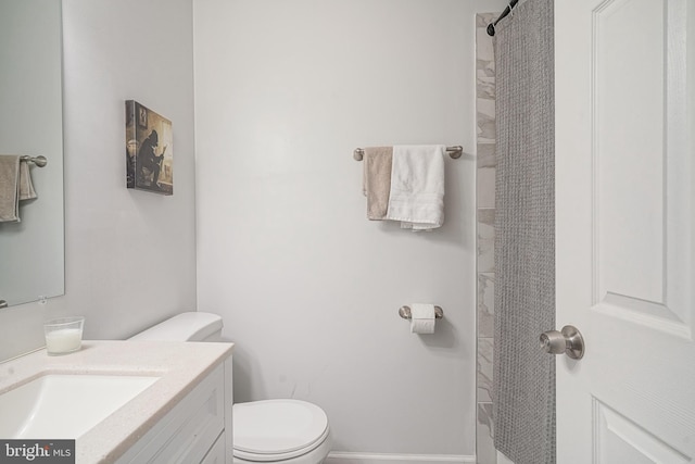 bathroom with toilet, curtained shower, baseboards, and vanity