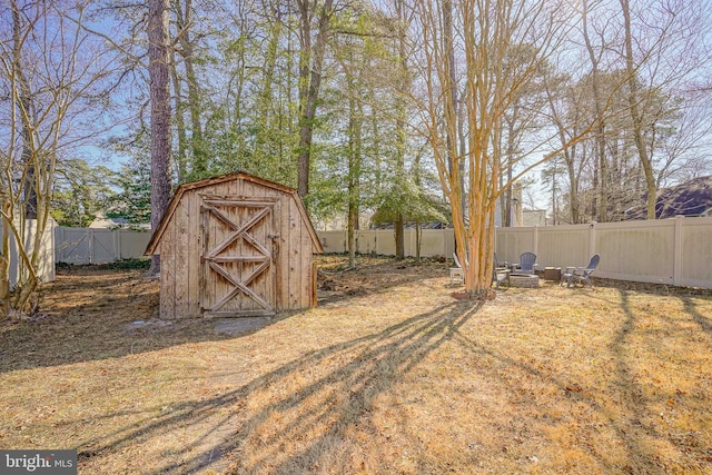 exterior space with a shed, a fire pit, a fenced backyard, and an outdoor structure