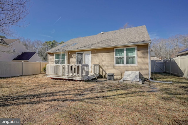 rear view of house featuring a gate, a lawn, a fenced backyard, and a wooden deck