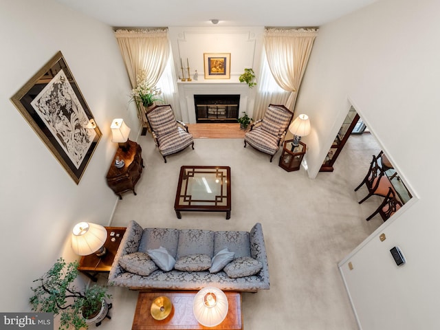 living area featuring carpet floors and a glass covered fireplace