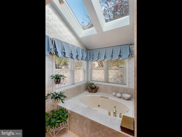 bathroom with a jetted tub and lofted ceiling with skylight