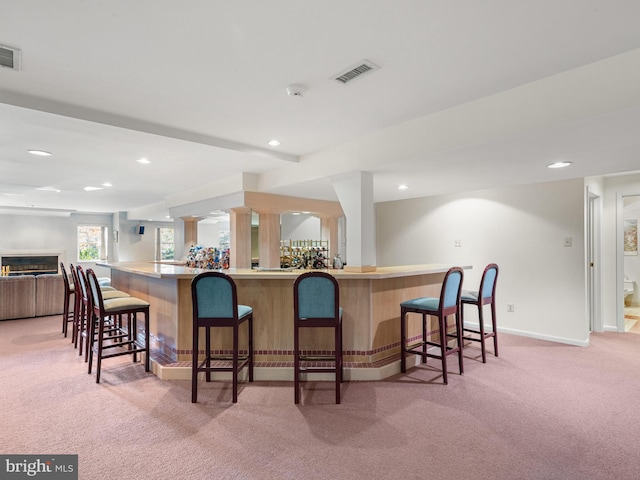 bar with recessed lighting, visible vents, light carpet, bar, and baseboards