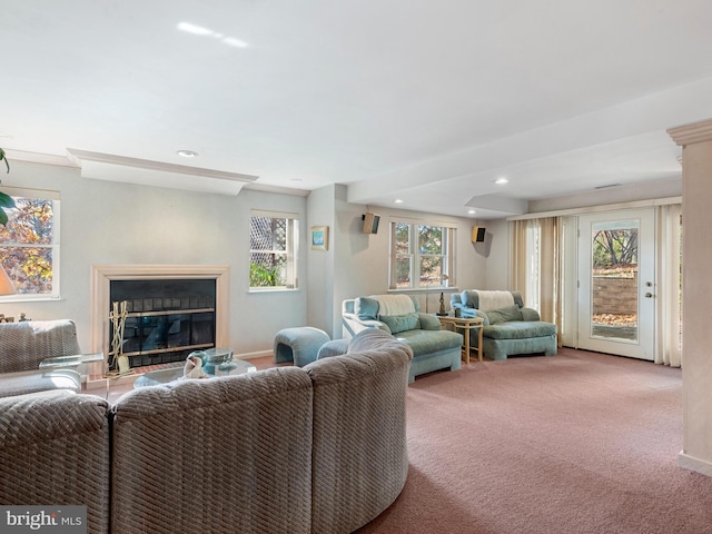 living area with a glass covered fireplace, light colored carpet, baseboards, and recessed lighting