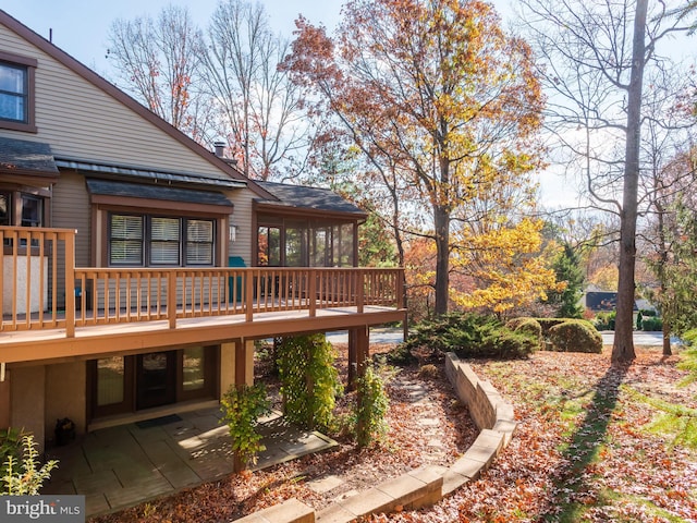 view of yard with a patio area, a deck, and a sunroom