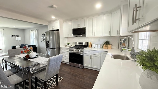 kitchen with dark wood finished floors, light countertops, appliances with stainless steel finishes, white cabinetry, and a sink