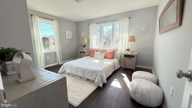 bedroom with multiple windows, baseboards, and dark wood finished floors