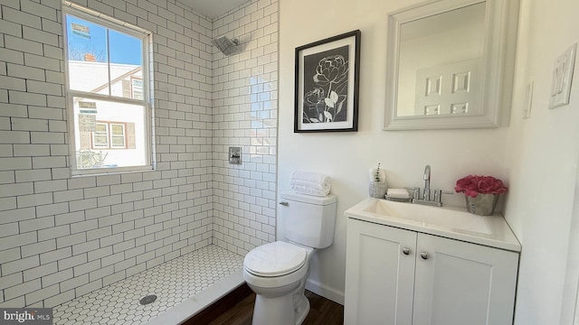 full bath featuring toilet, a stall shower, baseboards, and vanity