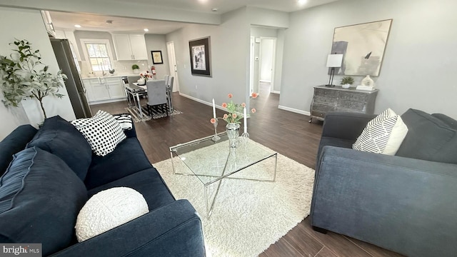 living room with dark wood-style floors, recessed lighting, and baseboards