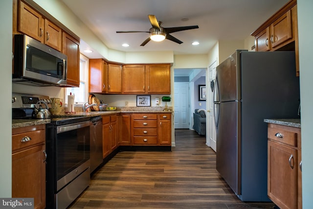 kitchen with brown cabinets, dark wood finished floors, stainless steel appliances, recessed lighting, and stone countertops