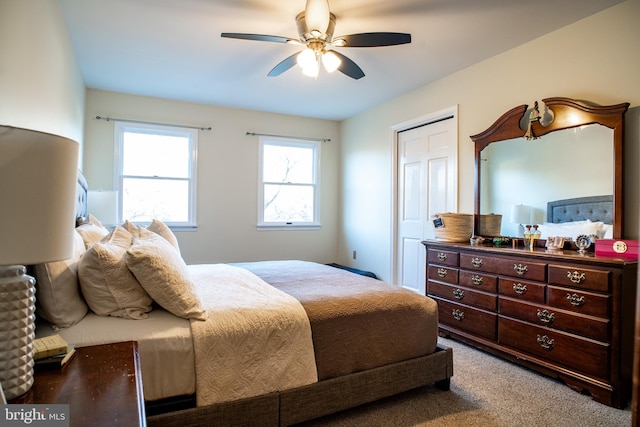 carpeted bedroom with ceiling fan and a closet