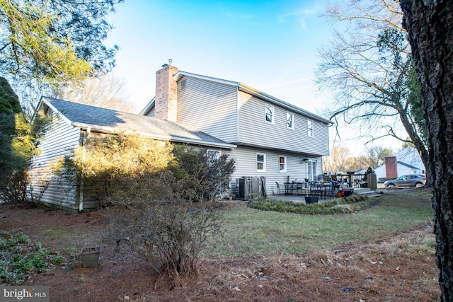 back of house featuring a patio area and a chimney